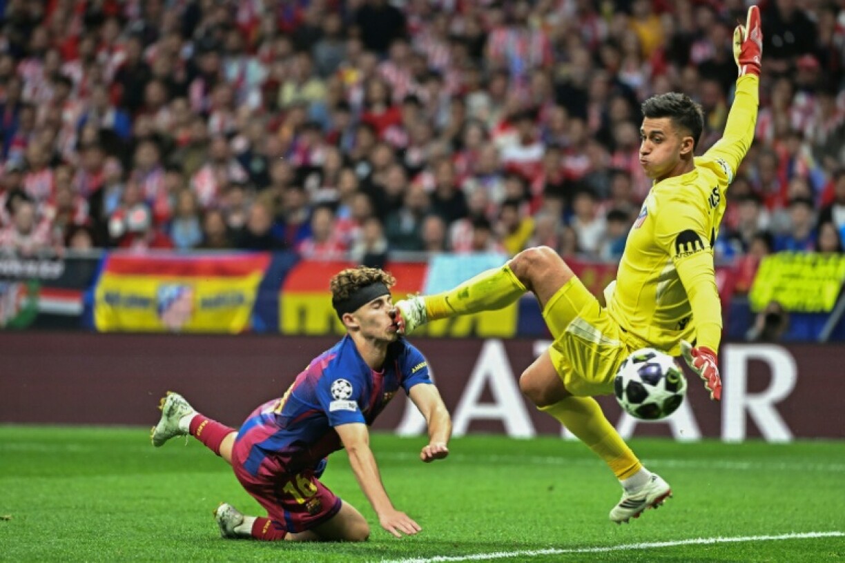Le milieu du Barça Fermin Lopez (G) touché par le gardien de l'Atlético Madrid Juan Musso lors du quart de finale de Ligue des champions, le 14 avril 2026 à Madrid