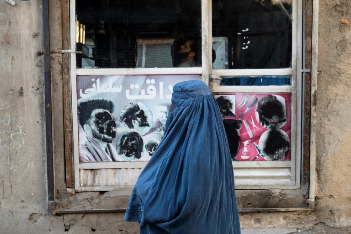 An Afghan woman stands at a window in Kabul on January 31, 2024