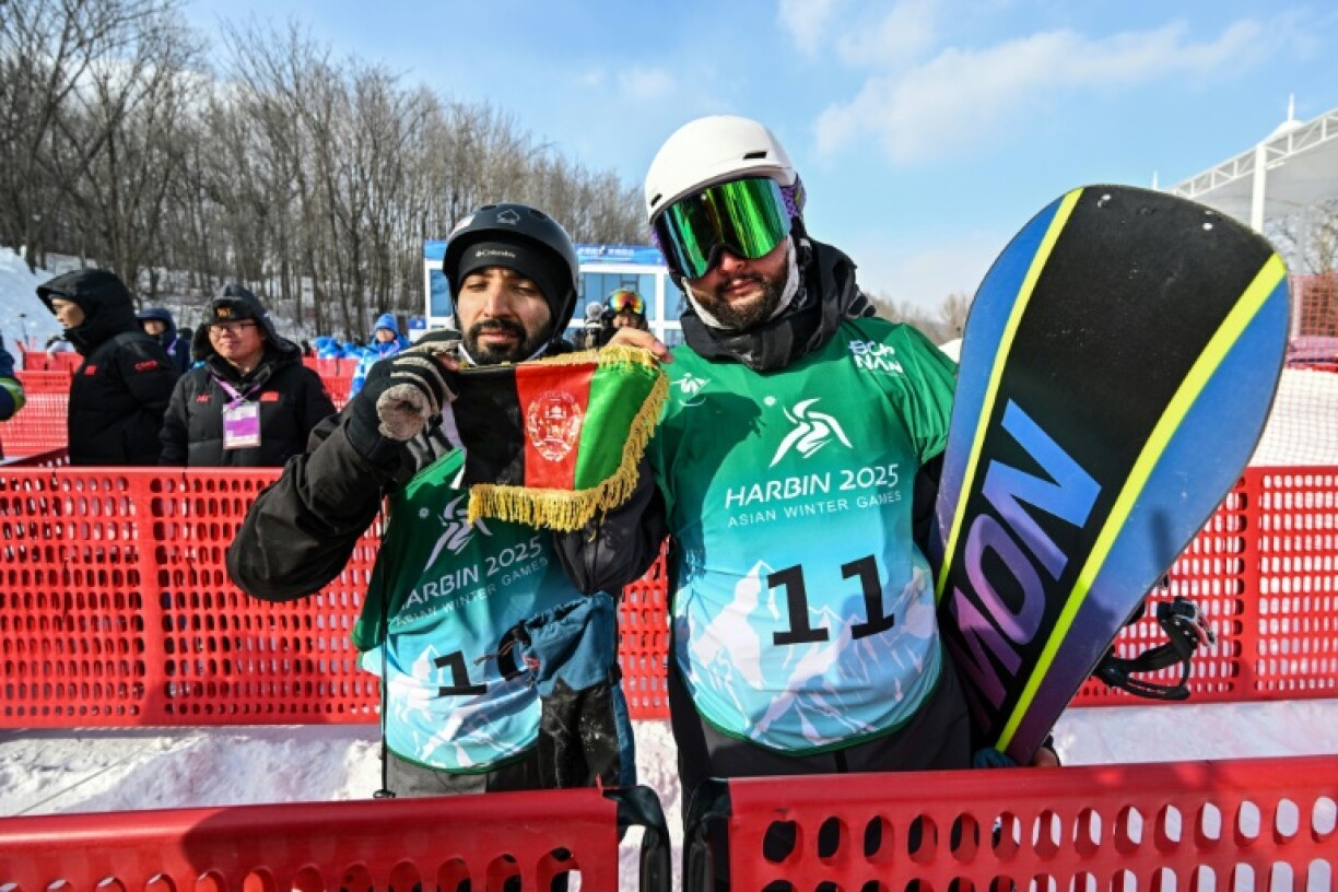 Afghanistan's Ahmad Romal Hayat (left) and Nizaruddin Ali Zada (R) with the Afghanistan flag at the Asian Winter Games