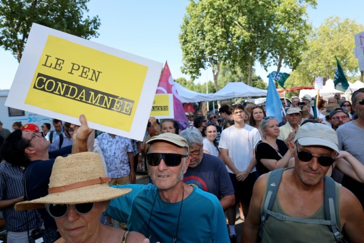 Des personnes manifestent contre Marine Le Pen, avant sa visite accompagnée du président du RN, Jordan Bardella, à La Flèche, le 8 juillet 2026 dans la Sarthe, au lendemain de l'annonce de sa candidature à la présidentielle de 2027 et de sa condamnation en appel dans l'affaire des assistants parlementaires européens