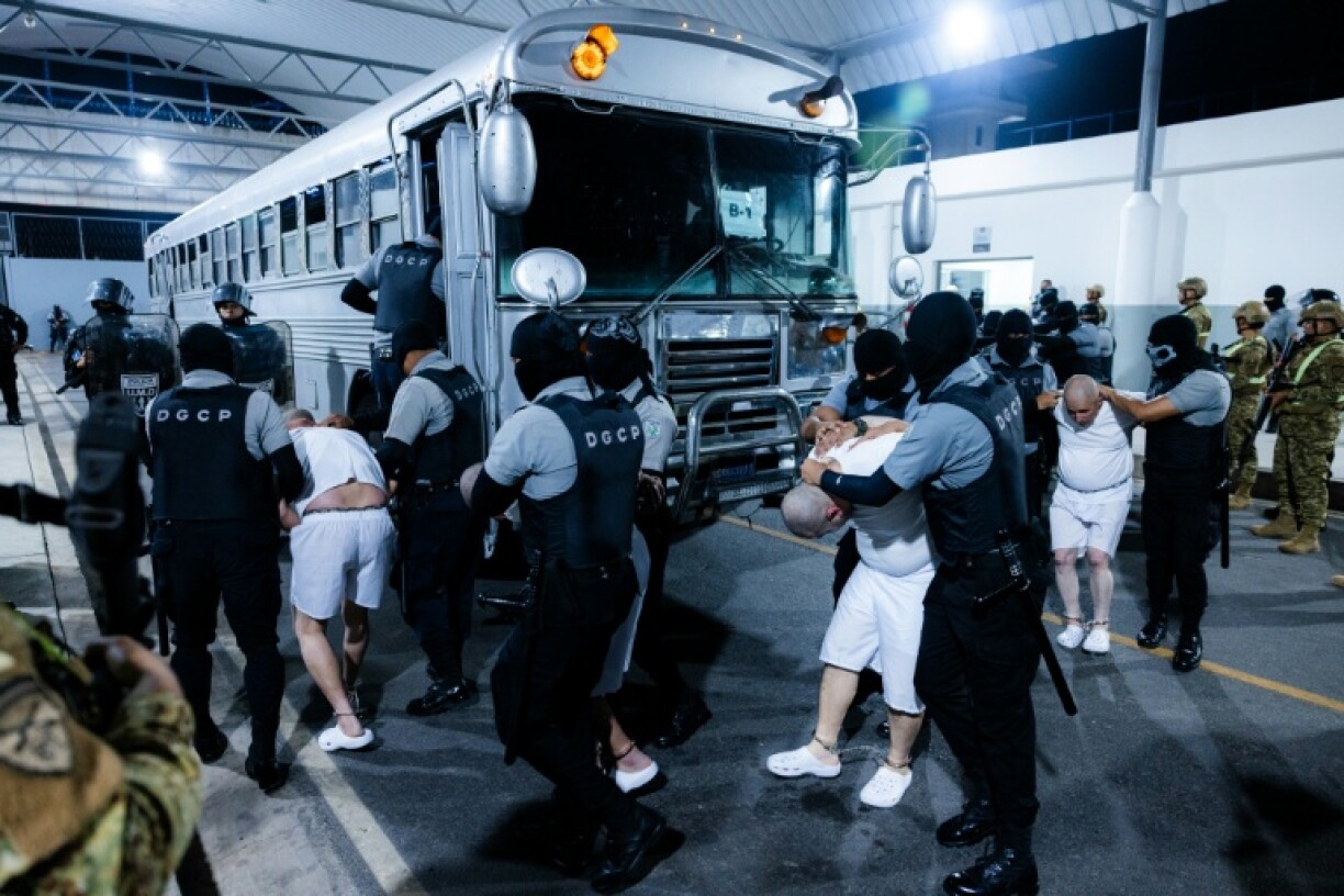 This handout picture released on March 31, 2025, by El Salvador's Presidency press office shows alleged members of the Venezuelan criminal organization Tren de Aragua and from the Salvadoran gang MS-13 being subdued upon their arrival at the Terrorism Confinement Center (CECOT) in the city of Tecoluca, El Salvador.