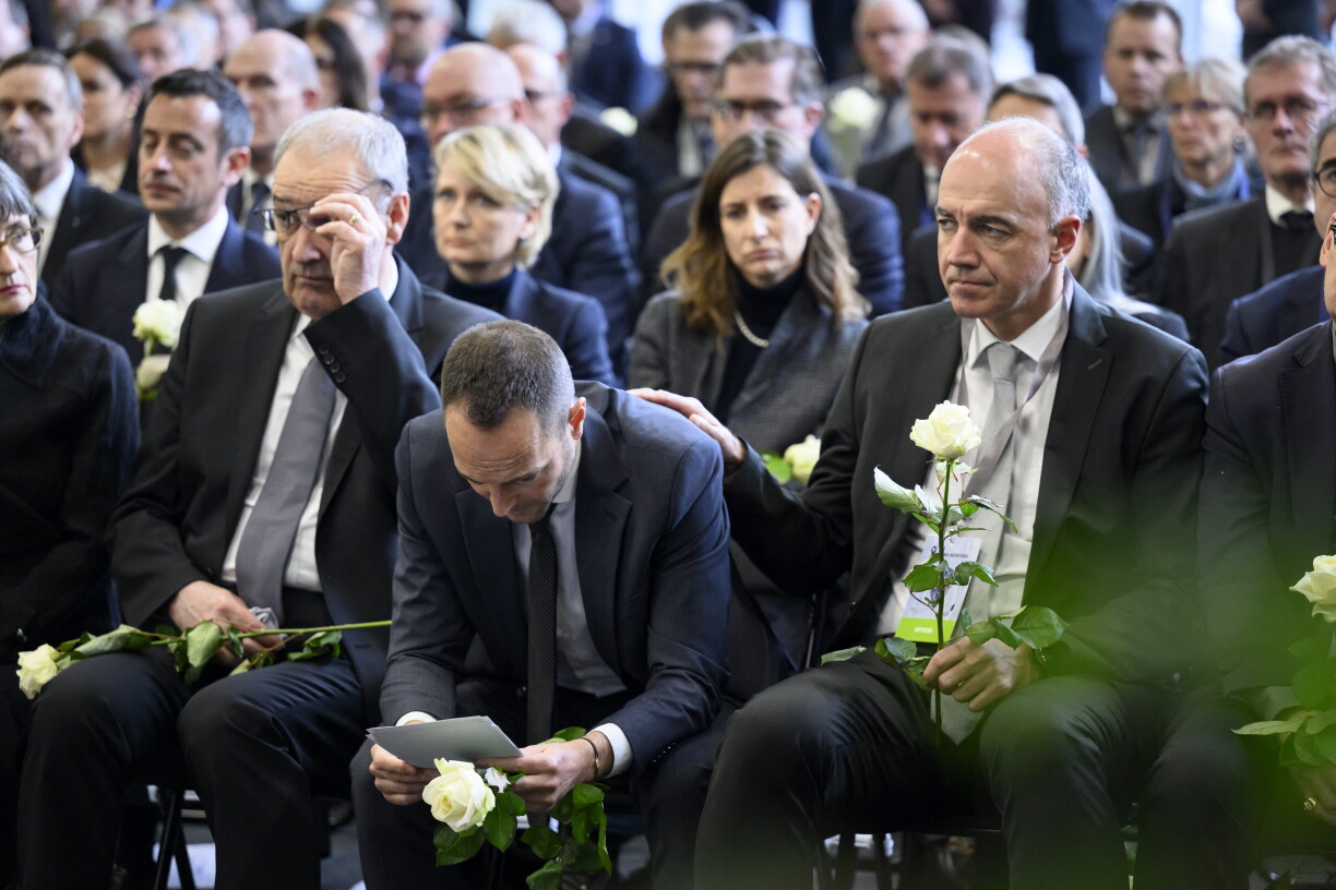 Swiss Federal President Guy Parmelin (L), Head of government of the Canton of Valais Mathias Reynard (C), State Councillor and President of the Council of State of the Canton of Valais Christophe Darbellay (R) attend a tribute ceremony for the victims of the deadly fire that ripped through the bar Le Constellation in Crans-Montana on New Year's Eve, in Martigny, on January 9, 2026.