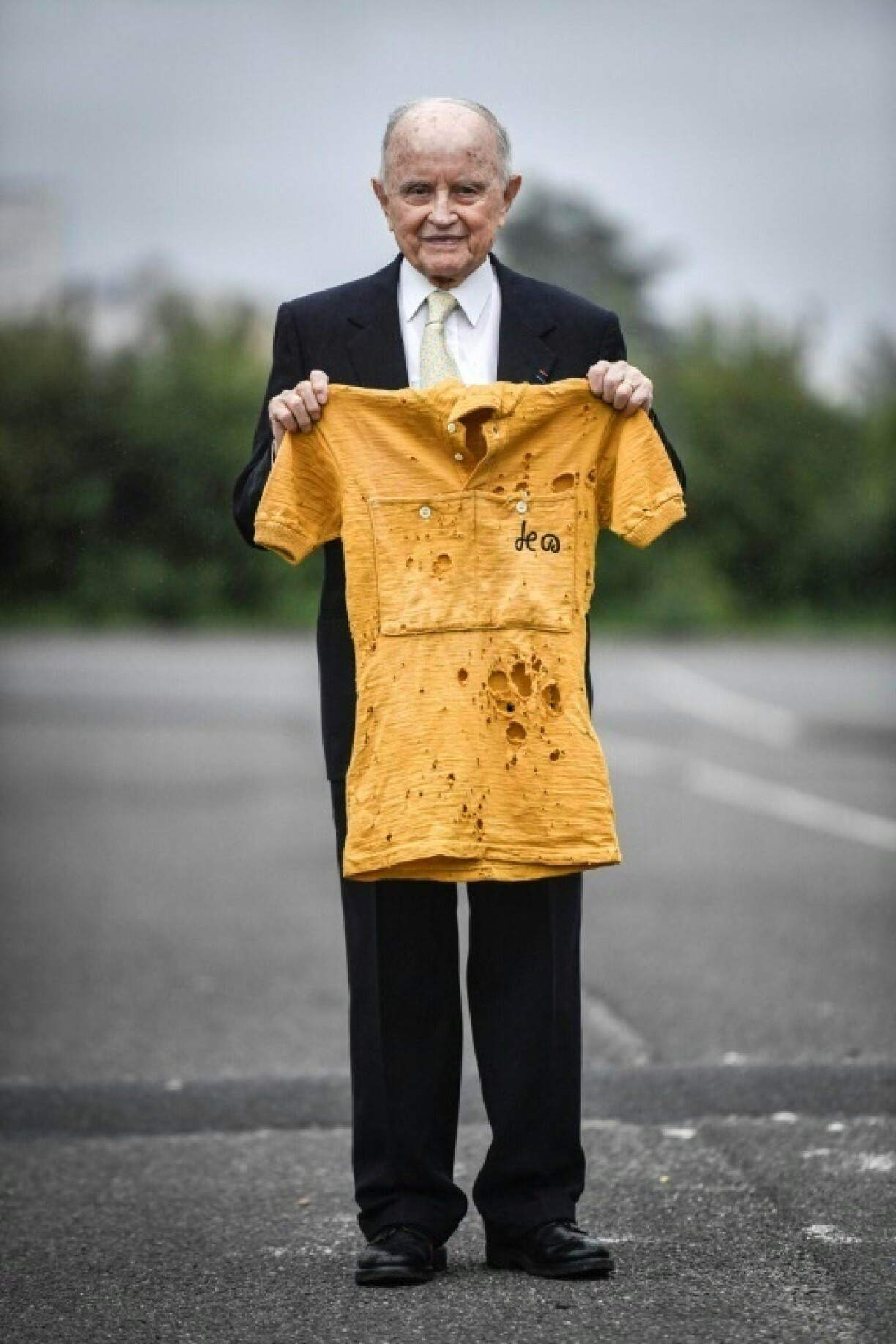 French cyclist Jacques Marinelli, who has died aged 99, holds the yellow jersey he wore for six days in the 1949 Tour de France in which he finished third