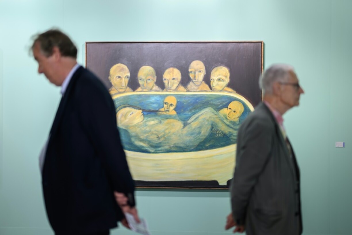 Visitors stand next to 'Die Wachter' by the Swiss artist Annette Barcelo at the Art Basel contemporary art fair