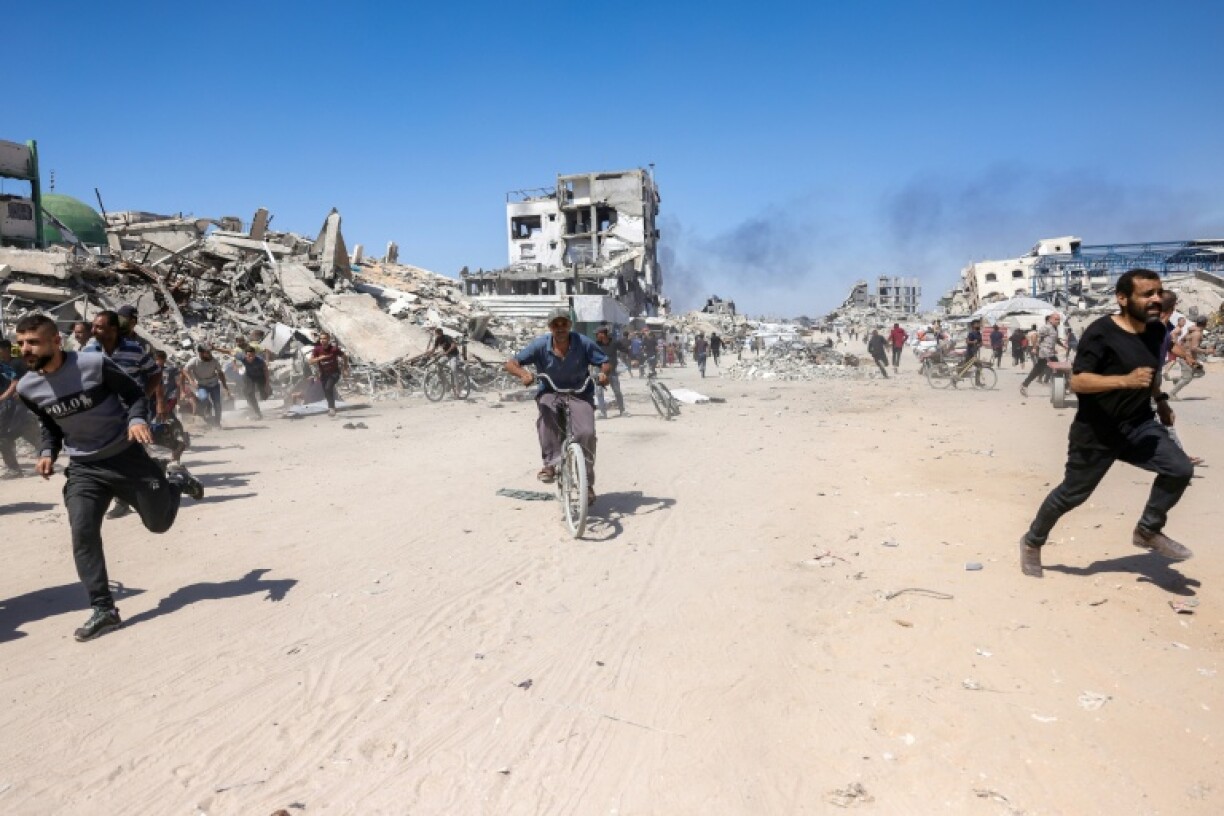 Palestinians run for cover during an Israeli drone strike in northern Gaza on May 23, 2025