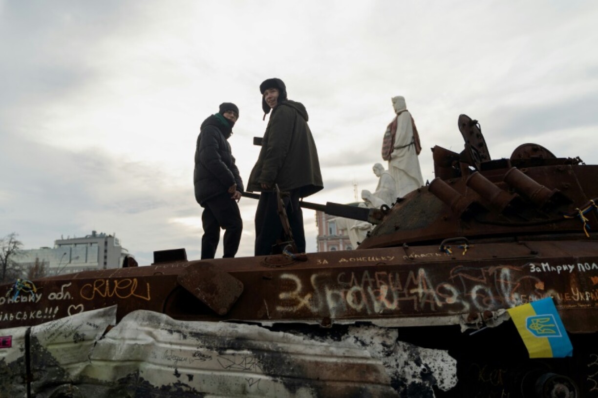 Children climb on a destroyed Russian personnel carrier at an open-air exhibition of destroyed military vehicles on Mykhailivska Square in Kyiv on January 8, 2025