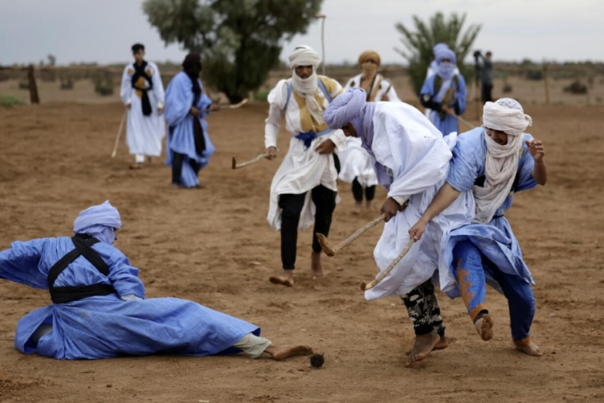 Moroccan nomads dressed in traditional garments take part in a sand hockey match during the Nomads Festival