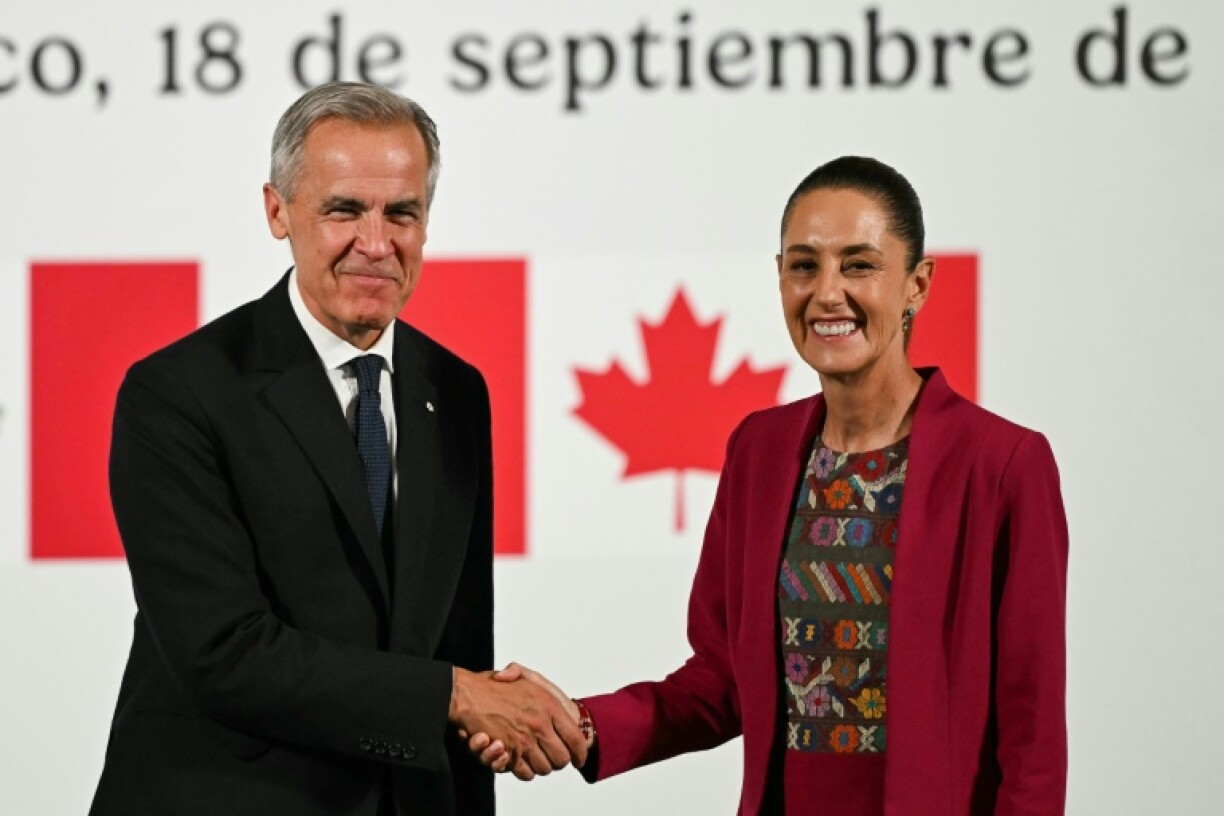 Canada's Prime Minister Mark Carney (L) and Mexico's President Claudia Sheinbaum (R) vowed at a meeting in Mexico to work together to safeguard the future of their three-way trade deal with the United States