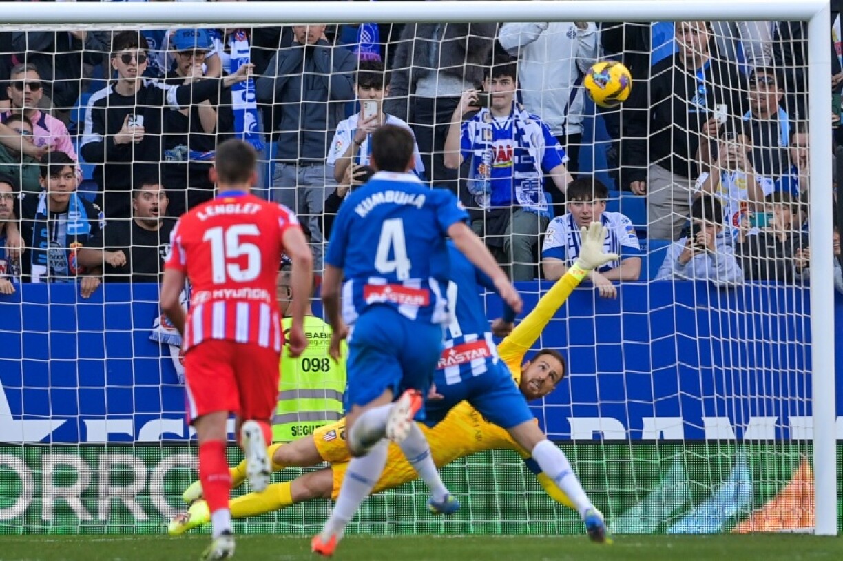 Atletico Madrid's Slovenian goalkeeper #13 Jan Oblak (R) fails to stop Javi Puado's penalty
