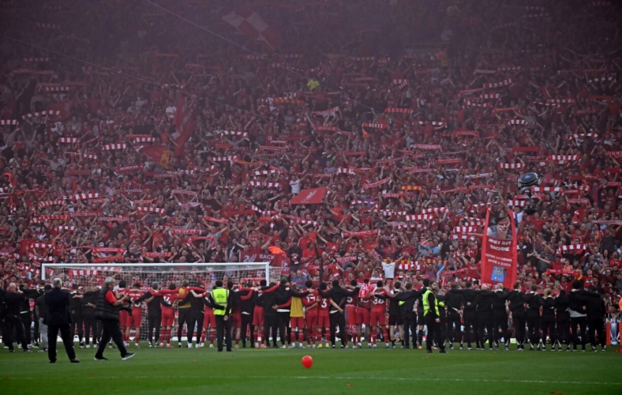 Liverpool players celebrate in front of their fans after clinching the Premier League title at Anfield