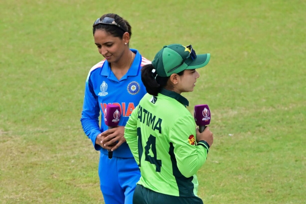 India's captain Harmanpreet Kaur and her Pakistani counterpart Fatima Sana walk past after the toss
