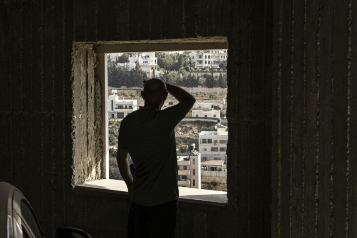 A Palestinian man looks on at empty homes after the Israeli army forces people to evacuate the Ein Deir Baha neighborhood in the occupied West Bank city of Hebron