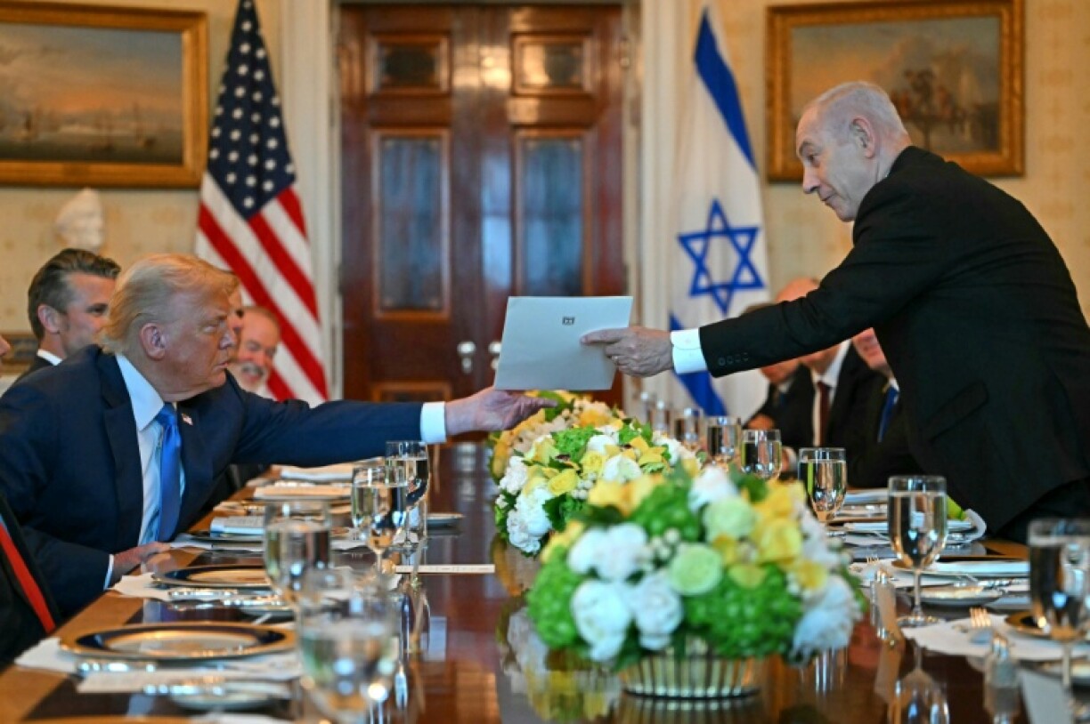 Le Premier ministre israélien Benjamin Netanyahu remet une lettre au président américain Donald Trump lors de leur rencontre à la Maison Blanche à Washington, DC, le 7 juillet 2025