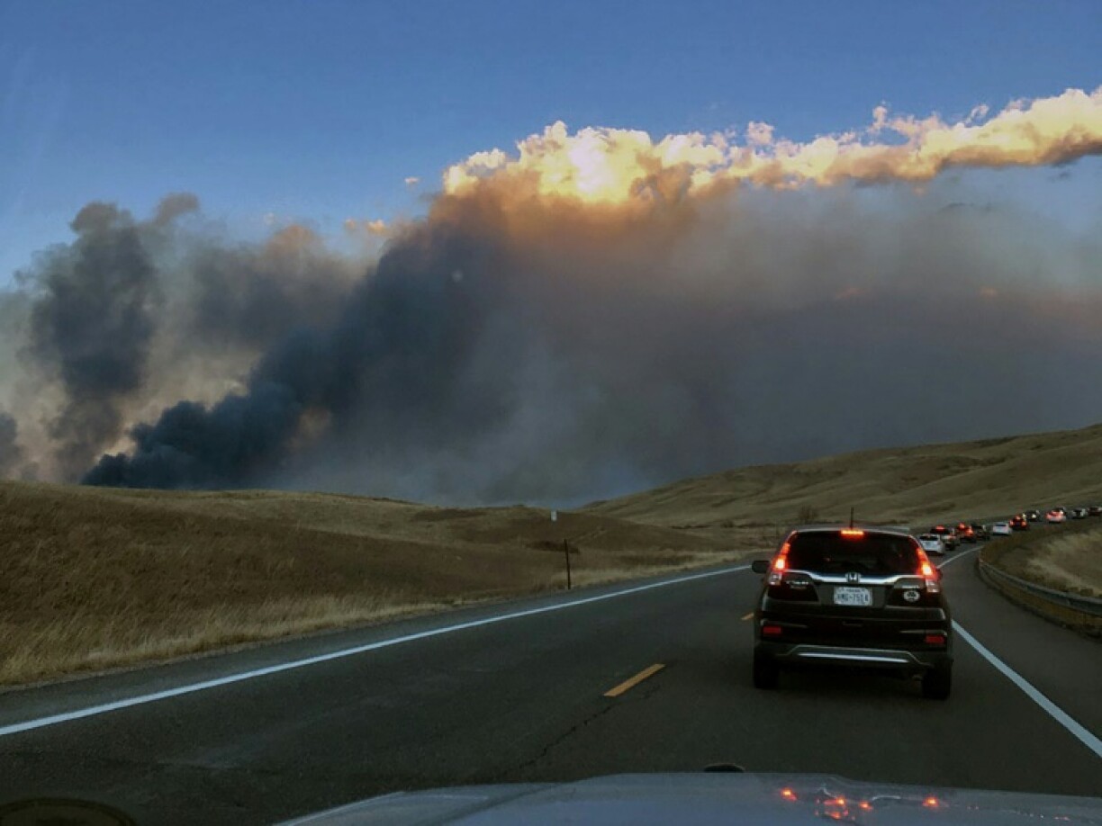 Une voiture de police roule sur une autorouté près d'un incendie, le 30 décembre 2021, à Rocky Flats, Broomfield, dans le Colorado