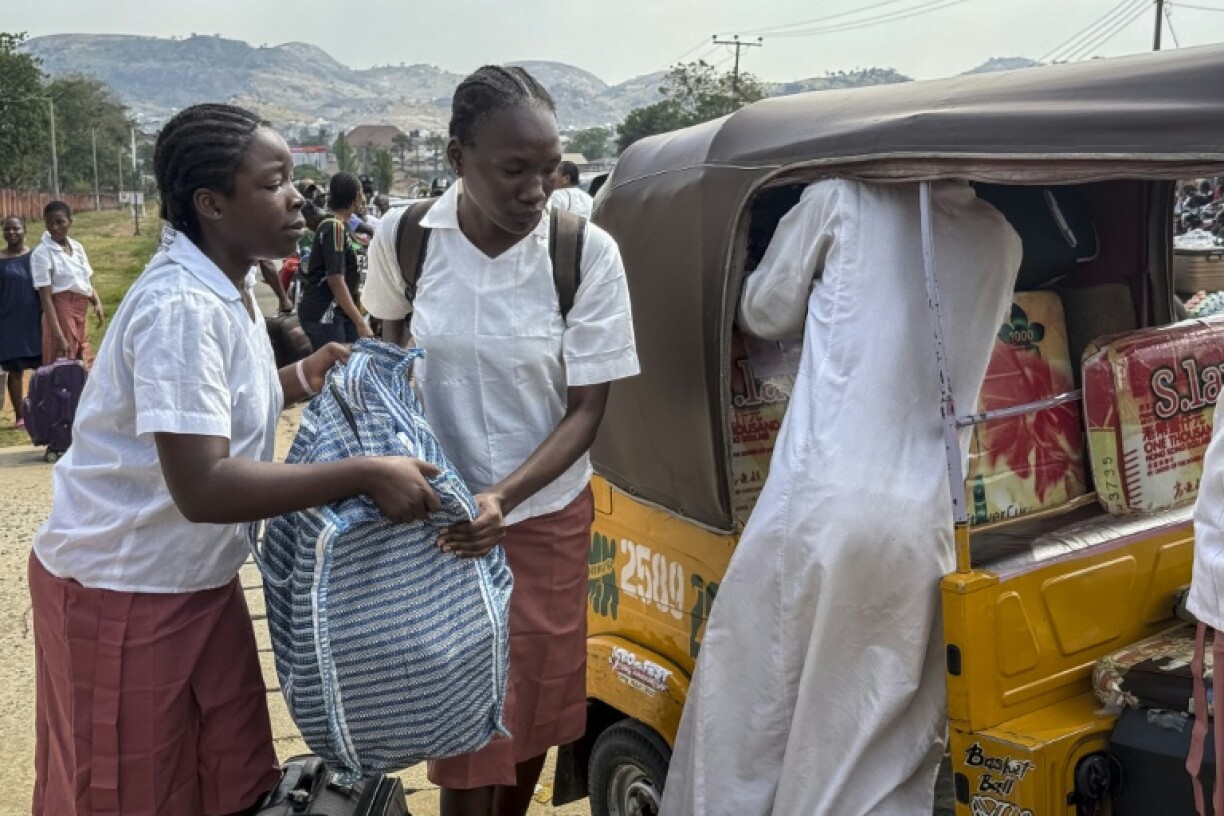 Des élèves chargent leurs bagages devant une école publique de filles à Bwari, dans les faubourgs d'Abuja, le 22 novembre 2025, fermée par les autorités après plusieurs enlèvements de masse dans des établissements scolaires
