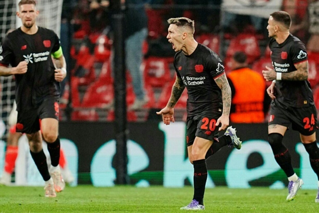 Bayer Leverkusen defender Alejandro Grimaldo (C) celebrates scoring another free kick