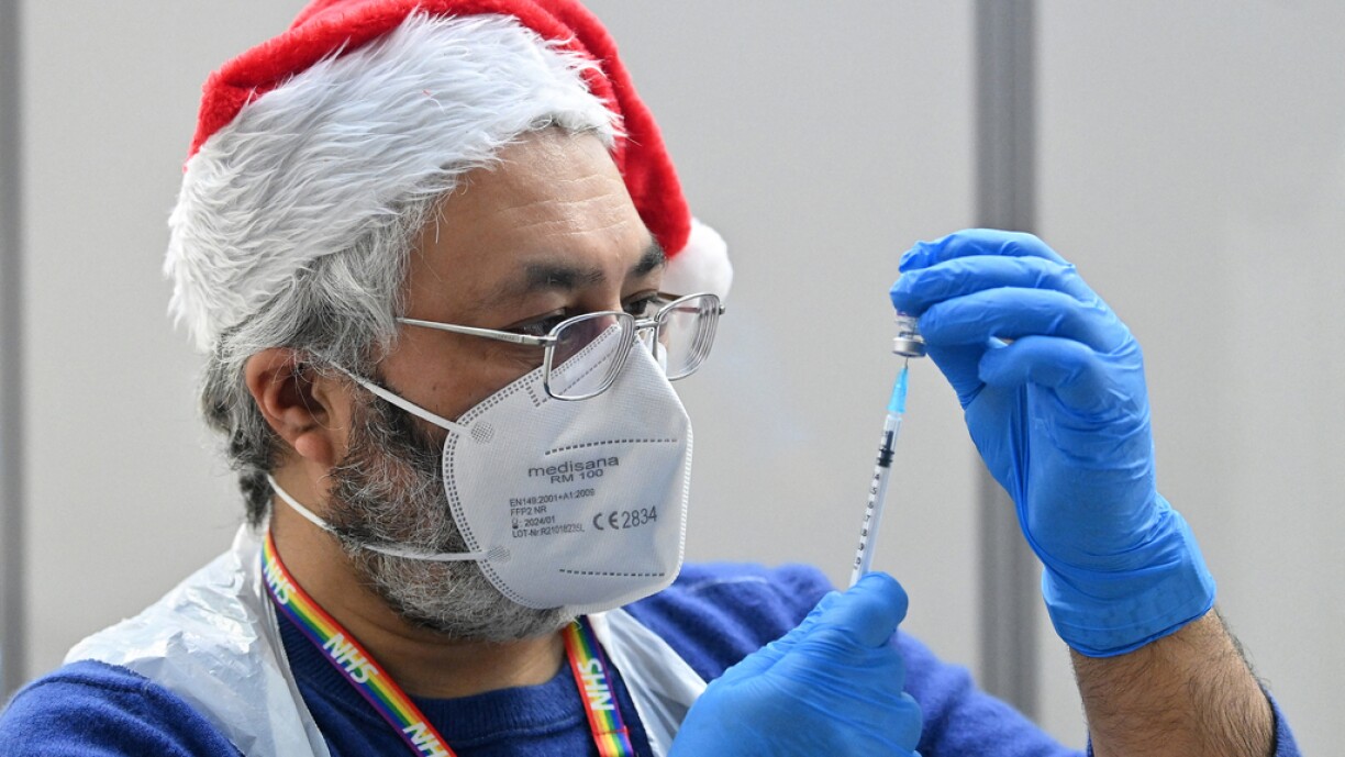 A health worker prepares a dose of the Covid-19 vaccine at a pop-up coronavirus vaccination centre at the Redbridge Town Hall, east London on December 25, 2021. British Prime Minister Boris Johnson in his Christmas Eve message exhorted the UK public to get jabbed as a