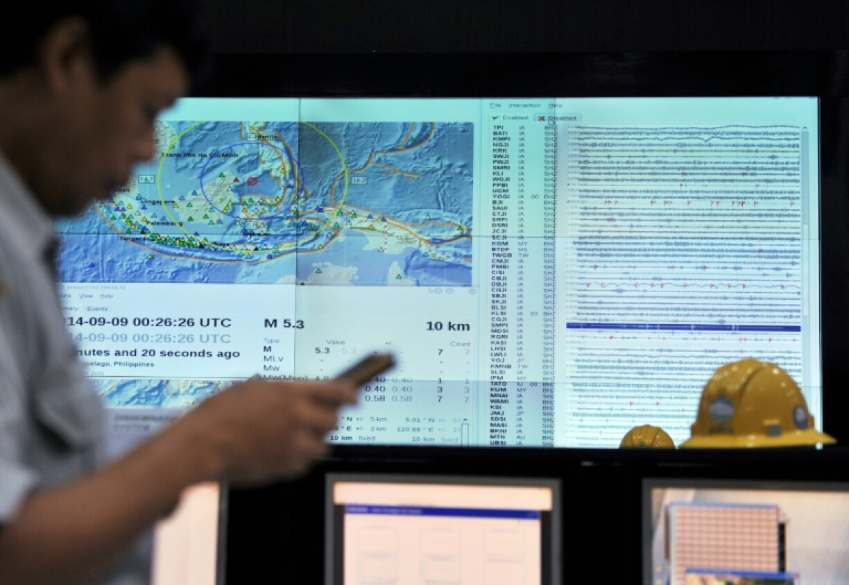 An Indonesian official checks his phone for an SMS earthquake and tsunami warning alert during an Indian Ocean-wide tsunami exercise to test readiness in case of a massive earthquake and tsunami alert
