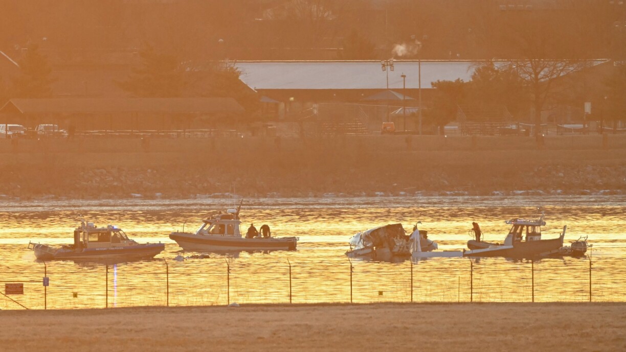 Part of the wreckage is seen as rescue boats search the waters of the Potomac River after a plane on approach to Reagan National Airport crashed into the river outside Washington DC on 30 January 2025.