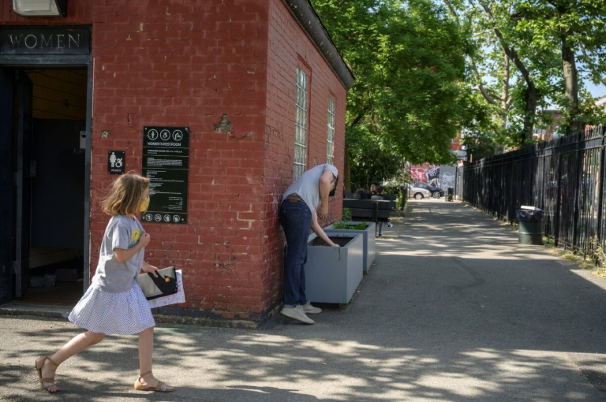 Steve Wasterval cache l'un de ses tableaux miniatures dans le quartier de Greenpoint, à New York, le 25 mai 2021