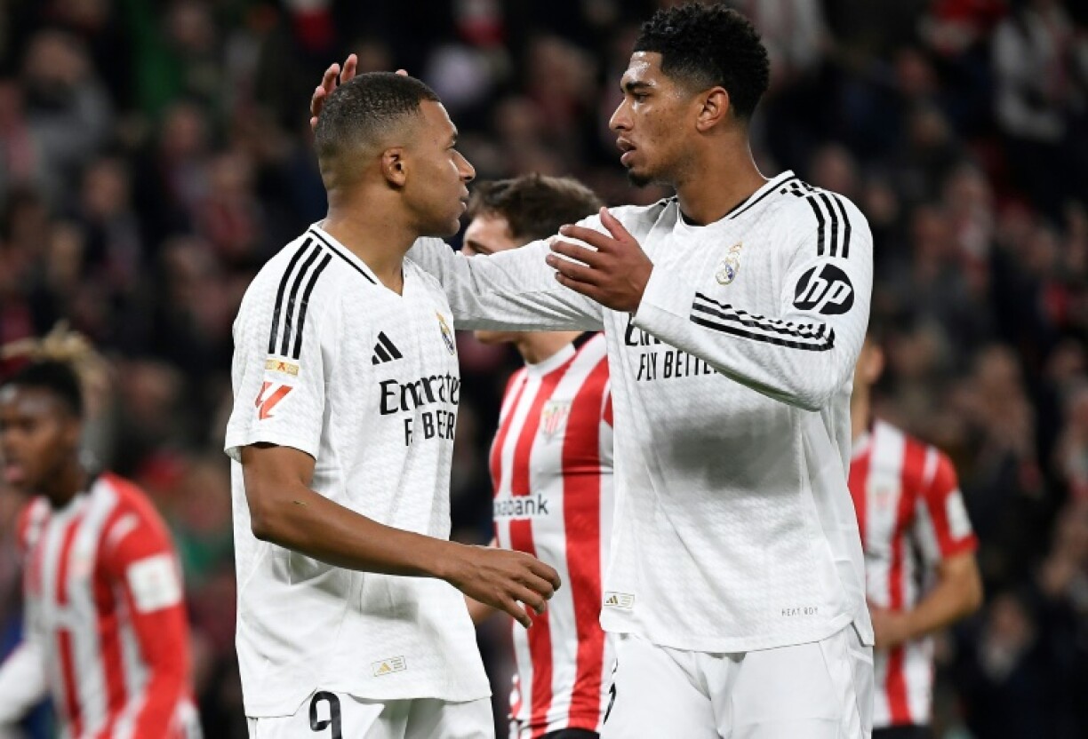 Real Madrid's French forward Kylian Mbappe (L) is comforted by Jude Bellingham after missing his penalty