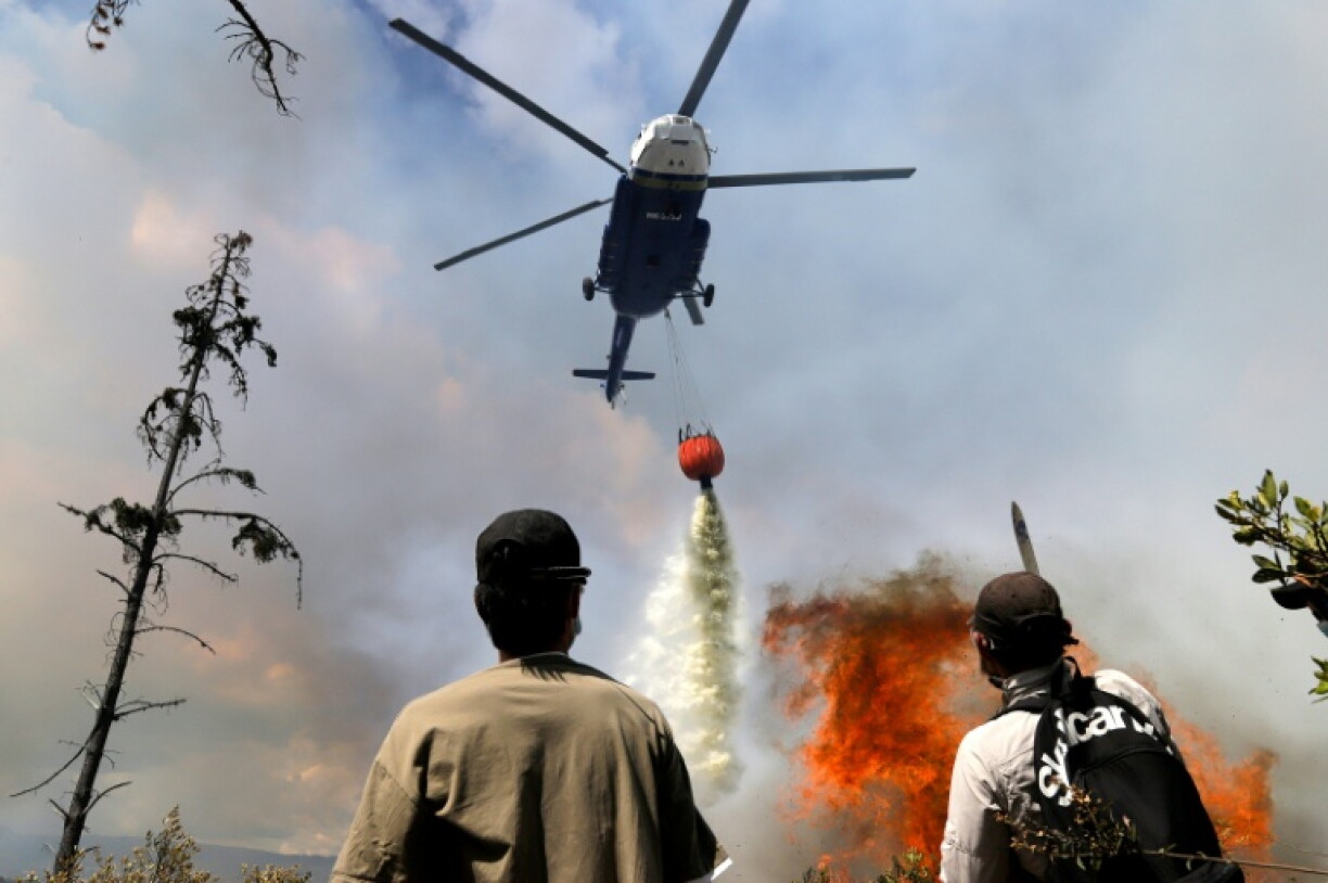 Un hélicoptère largue de l'eau sur un feu de forêt sur la colline de San Marcos, dans la municipalité de Villa de Leyva, le 20 septembre 2026 en Colombie