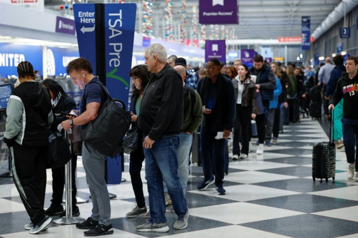 Travelers wait in line at a security checkpoint at O'Hare International Airport in Chicago, Illinois on November 7 2025