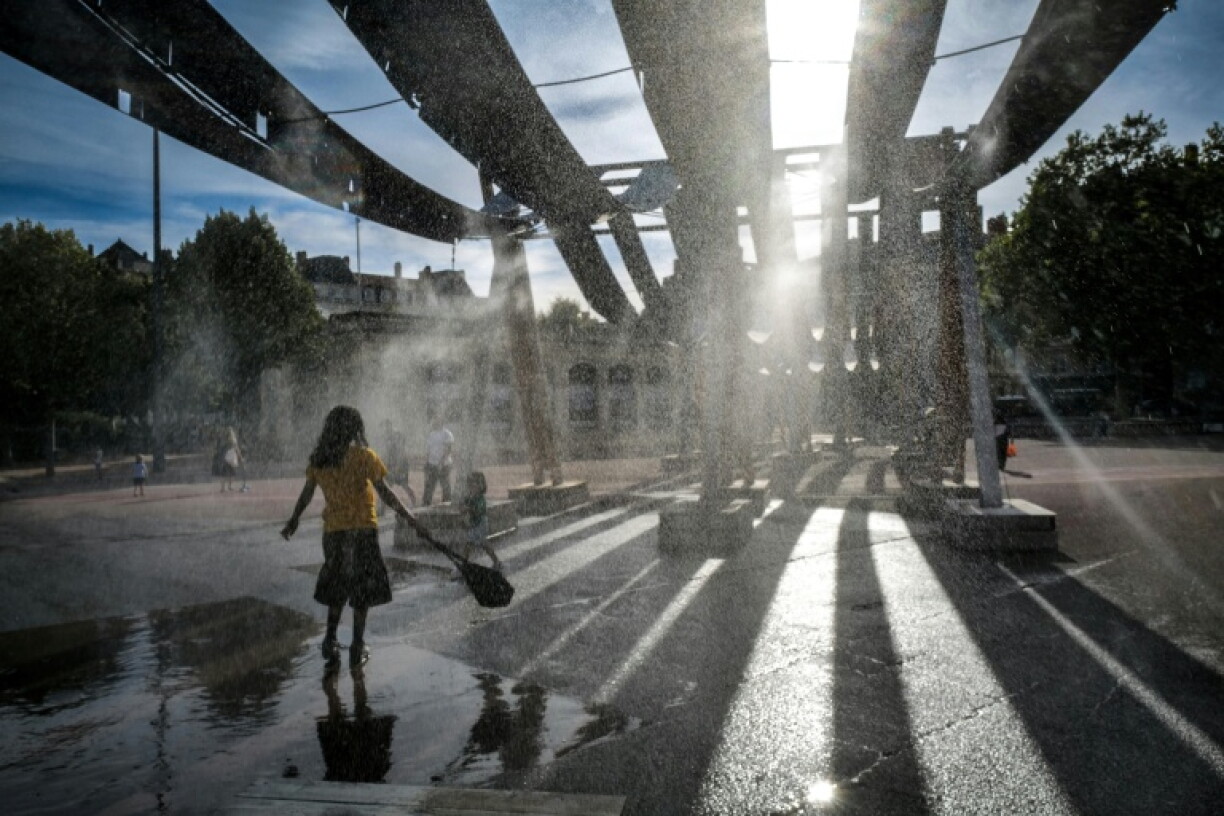 Pedestrians cool off during a heatwave in France