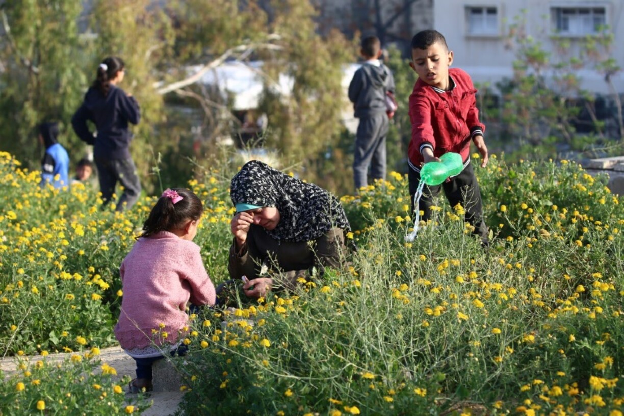 Des familles sur les tombes de leurs proches, à Nuseirat, dans le centre de la bande de Gaza, au premier jour de l'Aïd-el-Fitr, le 30 mars 2025