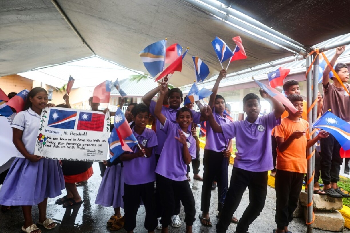 Students wave Taiwanese and Marshall Islands flags to welcome Taiwanese President Lai Ching-te in Majuro