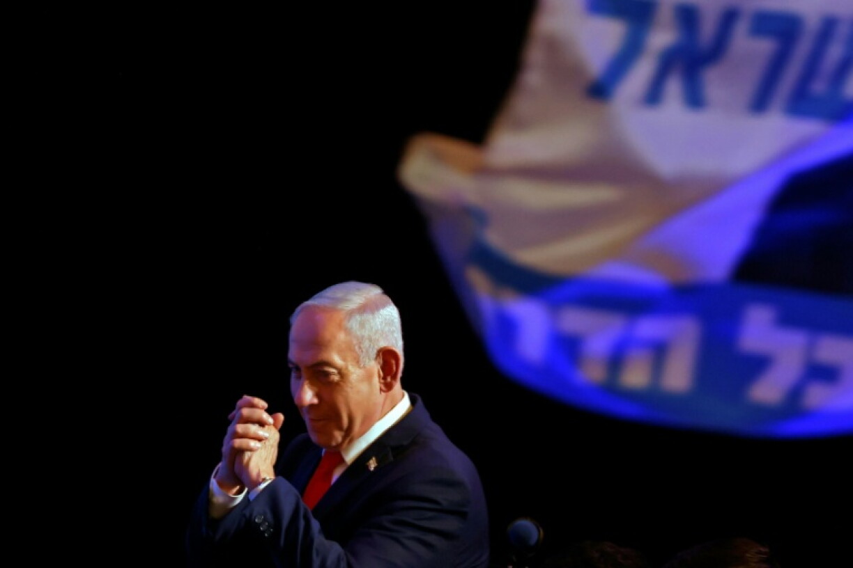 Israel's Prime Minister Benjamin Netanyahu gestures to his supporters at the election night rally after the first exit polls were announced, in Jerusalem