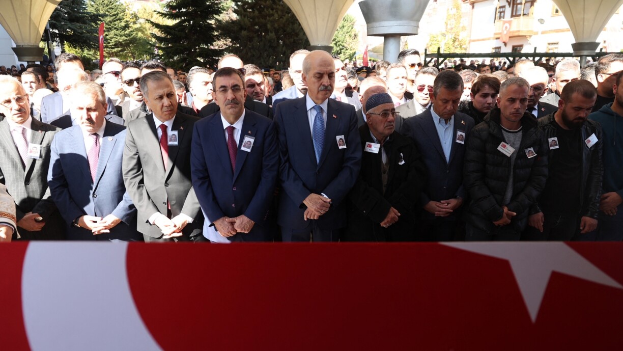 Turkish Interior Minister Ali Yerlikaya (3rd L), Head of Grand National Assembly of Turkey Numan Kurtulmus (C) and family members pray over the coffin of killed taxi driver Murat Arslan during his funeral the day after he was killed in a bomb attack to the state-run Turkish Aerospace Industries (TAI) building, in Ankara on 24 October.